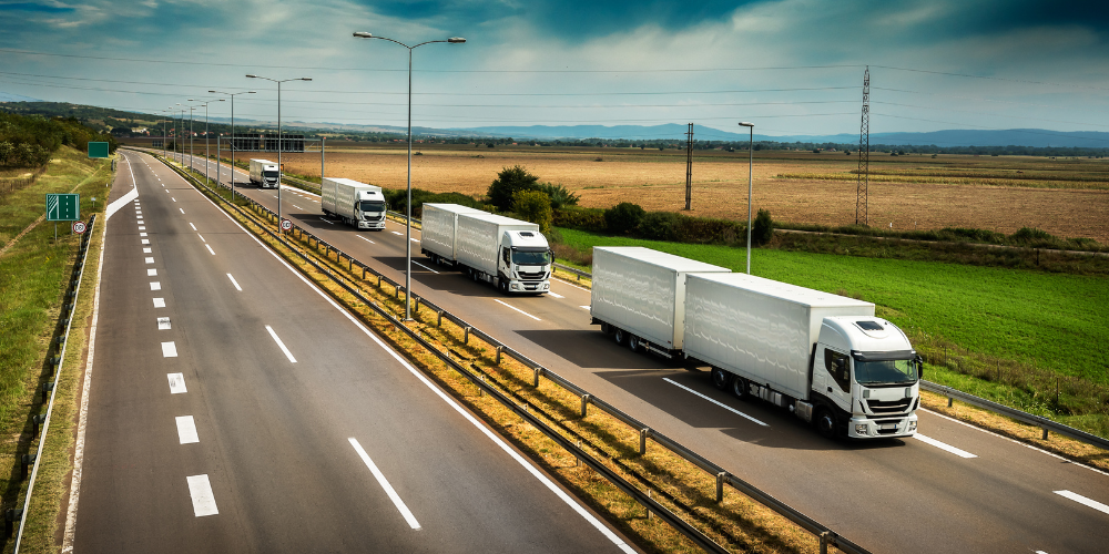 Home 1 White articulated lorries travelling in convoy along a motorway